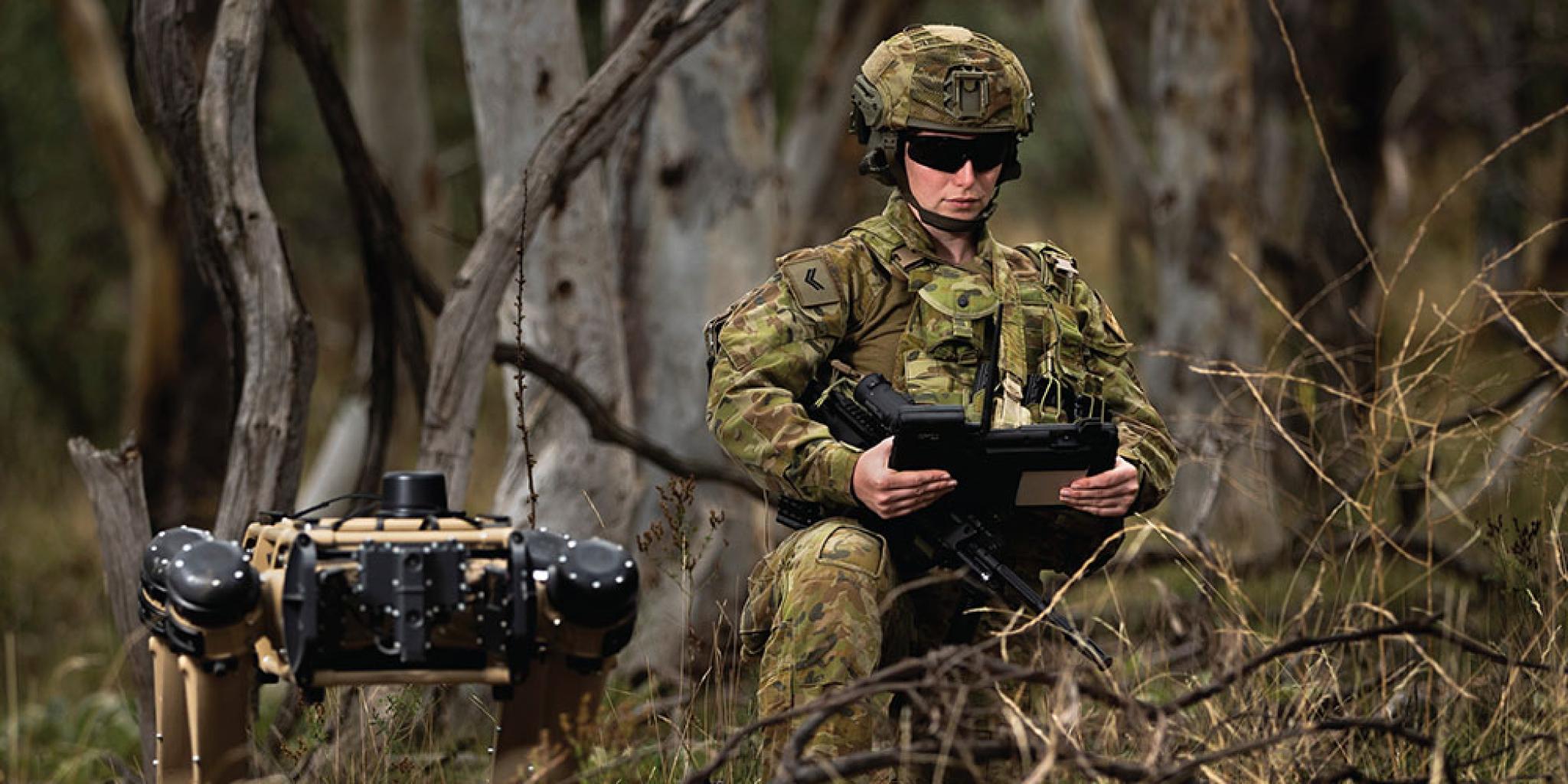Soldier with robot canine in the bush
