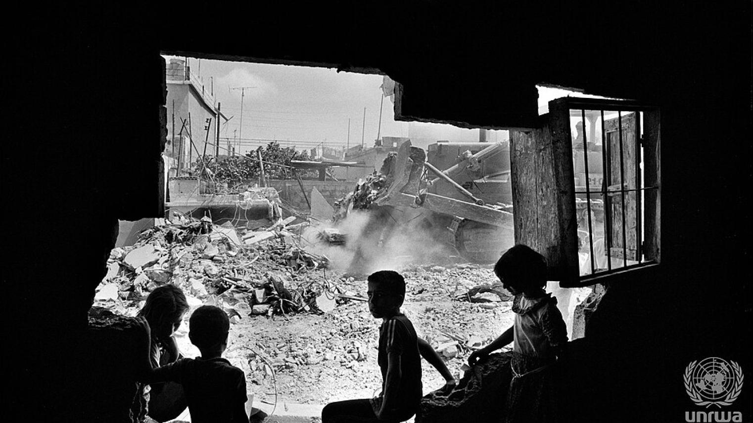 Children watching a bulldozer pushing remains of a destryed sheéter in Ein Hilweh camp, Lebannon